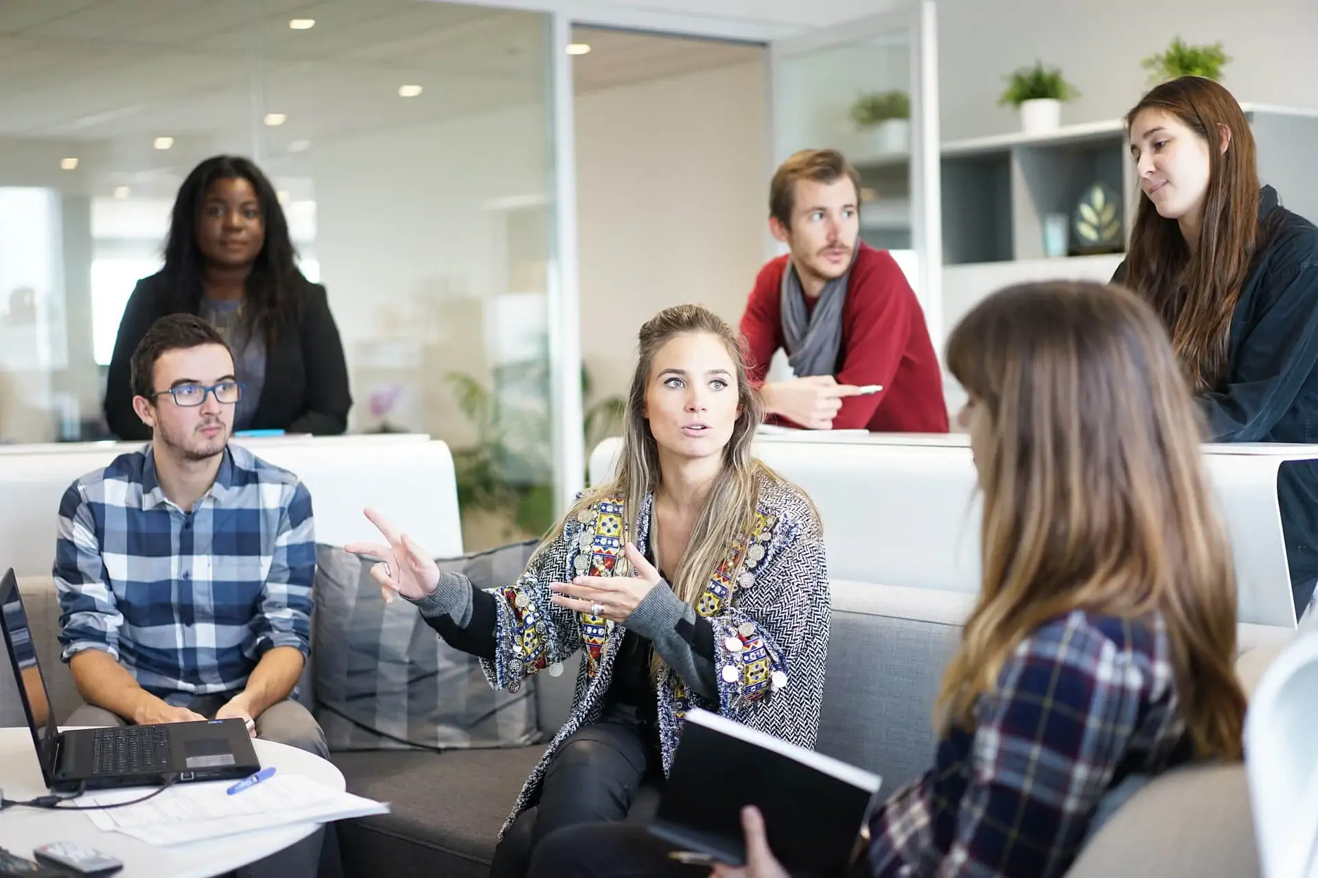 Reunión de trabajo en una oficina, con una persona explicando frente al equipo